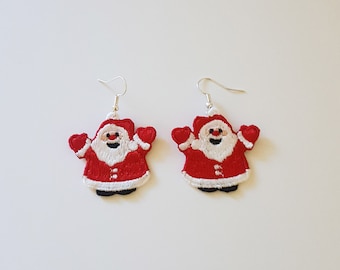 May include: A pair of red and white Santa Claus earrings. The earrings are made of felt and have a silver hook.