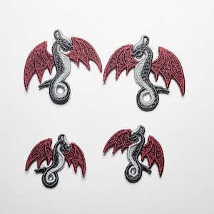 Puede incluir: Cuatro parches termoadhesivos con un dragón plateado con alas rojas. El dragón está enroscado con las alas extendidas. Los parches son perfectos para añadir un toque de fantasía a la ropa, bolsos u otros accesorios.