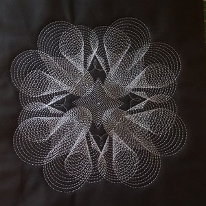 Pode incluir: Um tecido preto com um design geométrico branco, intrincado, de círculos sobrepostos e formas de estrelas.