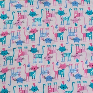 Cats with sweaters on pink kitten mat