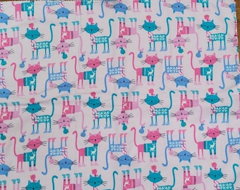 Cats with sweaters on pink kitten mat