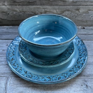 May include: A set of three blue ceramic dishes with a dragonfly design. The set includes a bowl, a smaller plate, and a larger plate.