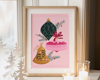 May include: A framed print with a pink background featuring three Christmas ornaments: a green bauble with white stars, a pink and white bauble with a red bow, and a gold bell with green leaves. The ornaments are surrounded by green pine branches.