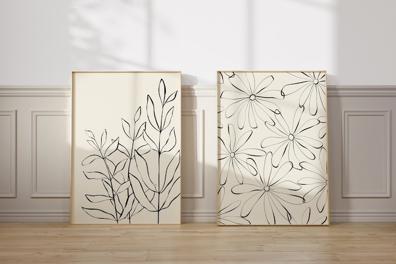 Puede incluir: Dos impresiones de arte en blanco y negro enmarcadas con dise&ntilde;os florales. La impresi&oacute;n de la izquierda presenta un grupo de hojas y tallos estilizados. La impresi&oacute;n de la derecha presenta un patr&oacute;n repetitivo de flores estilizadas.