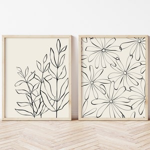 Puede incluir: Dos impresiones enmarcadas en blanco y negro con dise&ntilde;os bot&aacute;nicos. La impresi&oacute;n de la izquierda presenta un grupo de hojas y tallos. La impresi&oacute;n de la derecha presenta un patr&oacute;n repetitivo de flores estilizadas.