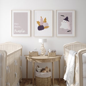 May include: A nursery room with two cribs, a side table with a lamp, and three framed prints on the wall. The prints feature a ghost, pumpkins, and the text "Hey there, Pumpkin".