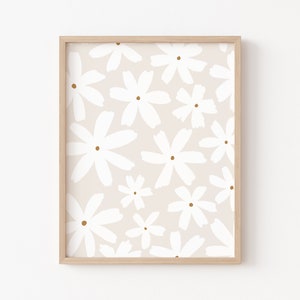 May include: A framed print with a white floral pattern on a light beige background. The flowers are stylized and have a simple, minimalist design.