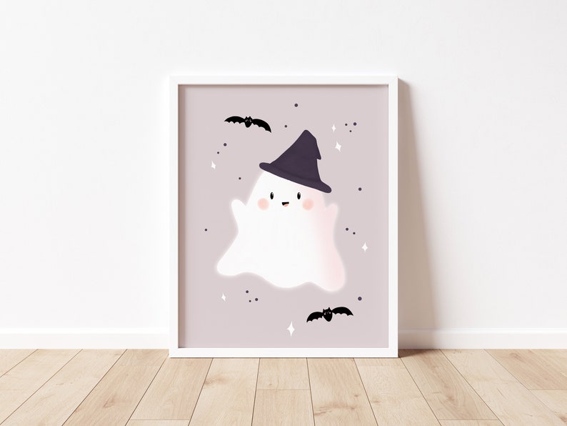 May include: A white ghost wearing a black witch hat with a pink background and black bats. The ghost has a happy face with rosy cheeks.