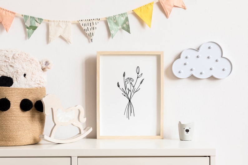 May include: A white wooden rocking horse, a white ceramic bear planter, and a framed black and white line drawing of flowers are displayed on a white dresser with a white cloud-shaped light fixture on the wall behind them. A white stuffed animal is in a woven basket.
