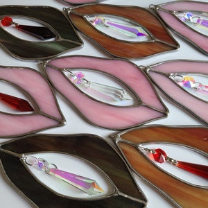 Puede incluir: Un conjunto de ocho adornos de vidrio de colores en forma de labios con detalles de cristal. Cada adorno presenta un color y un dise&ntilde;o diferente, incluyendo rosa, marr&oacute;n, negro y rojo.