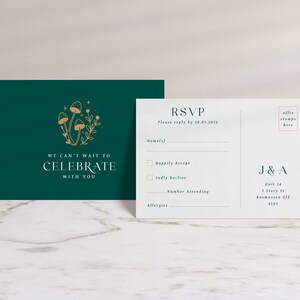 May include: Two-piece wedding stationery set. One card is dark teal with gold mushroom illustration and text "We can't wait to celebrate with you." The other is a white RSVP card with fill-in fields and "RSVP" text.