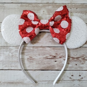 May include: White headband with large red and white polka dot bow and white sequin ears.