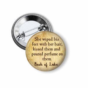 May include: A white ceramic mug with a black handle and the text "But First, Coffee" in a bold, black font. The mug is set against a blurred background, suggesting a cozy setting.