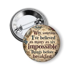 May include: A round pinback button featuring a vintage-style cream background with ornate floral and keyhole illustrations. The text reads: Why, sometimes I've believed as many as six impossible things before breakfast. A metal pin is attached to the back.