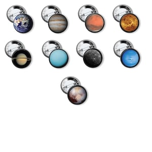 May include: A collection of nine circular pin-back buttons, each featuring a high-resolution image of a planet or celestial body from the solar system, including Earth, Jupiter, Mars, Venus, Saturn, Uranus, Mercury, Neptune, and Pluto.