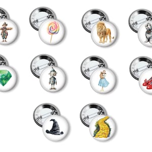 May include: A collection of round pinback buttons featuring illustrations of characters and symbols from The Wizard of Oz. Includes the Scarecrow, a lollipop, a lion, a dog, a green gem, the Tin Man, Dorothy, red shoes, a witch's hat, and the yellow brick road.