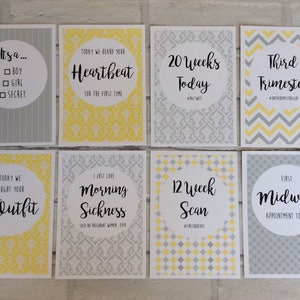 Pu&ograve; includere: Un set di otto biglietti di pietre miliari della gravidanza con testo in nero, giallo e grigio. Le carte presentano frasi come "Heartbeat", "20 Weeks Today" e "Third Trimester". Le carte hanno motivi decorativi e sono progettate per documentare la gravidanza.