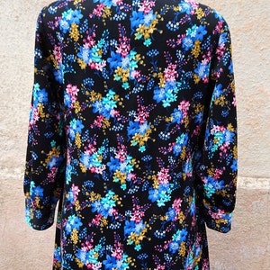 May include: A long-sleeved dress with a black background and a floral print in shades of blue, pink, and gold.