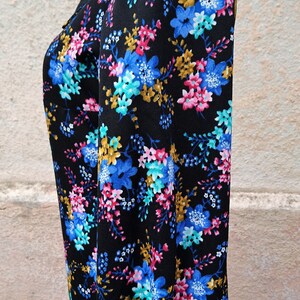 May include: A black long-sleeved dress with a high neck and a floral print in shades of blue, pink, and yellow.