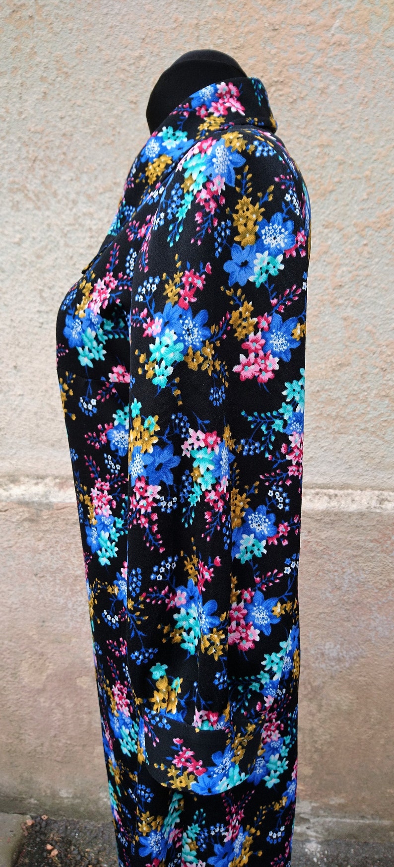 May include: A black long-sleeved dress with a high neck and a floral print in shades of blue, pink, and yellow.