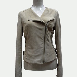 May include: A light brown suede jacket with a zipper closure and a collar. The jacket has a fitted silhouette and long sleeves.