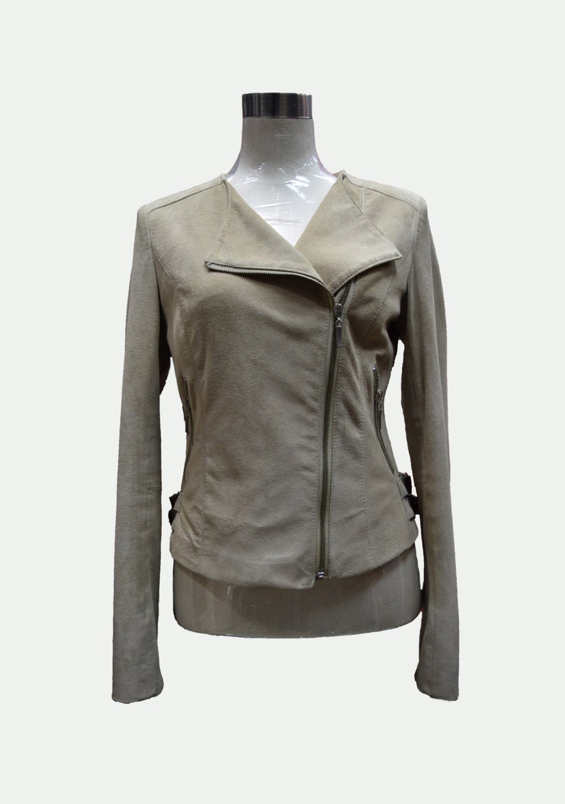 May include: A light brown suede jacket with a zipper closure and a collar. The jacket has a fitted silhouette and long sleeves.