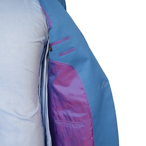 May include: A light blue blazer with a purple and white checkered lining. The blazer is unbuttoned and the lining is visible.