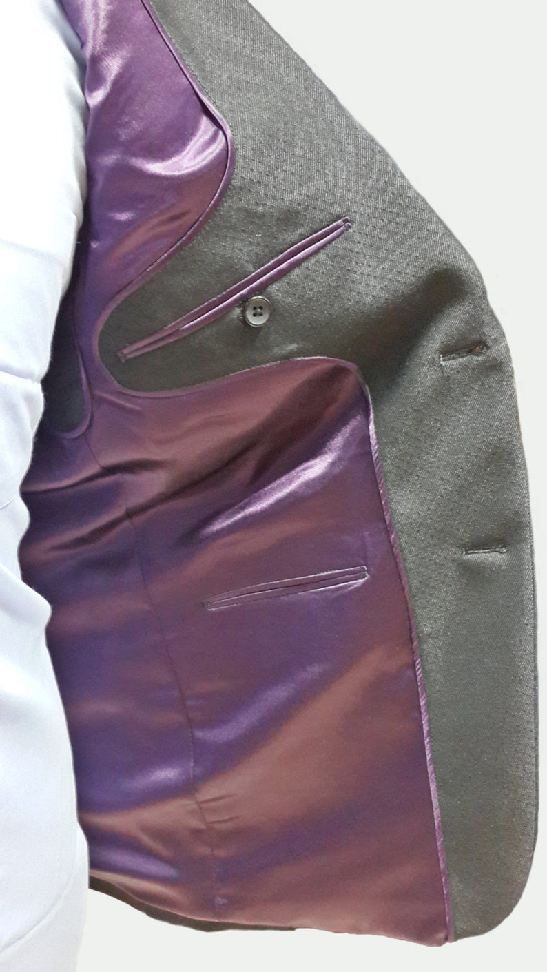 May include: A gray blazer with a purple satin lining. The blazer has a button closure and two pockets on the inside.