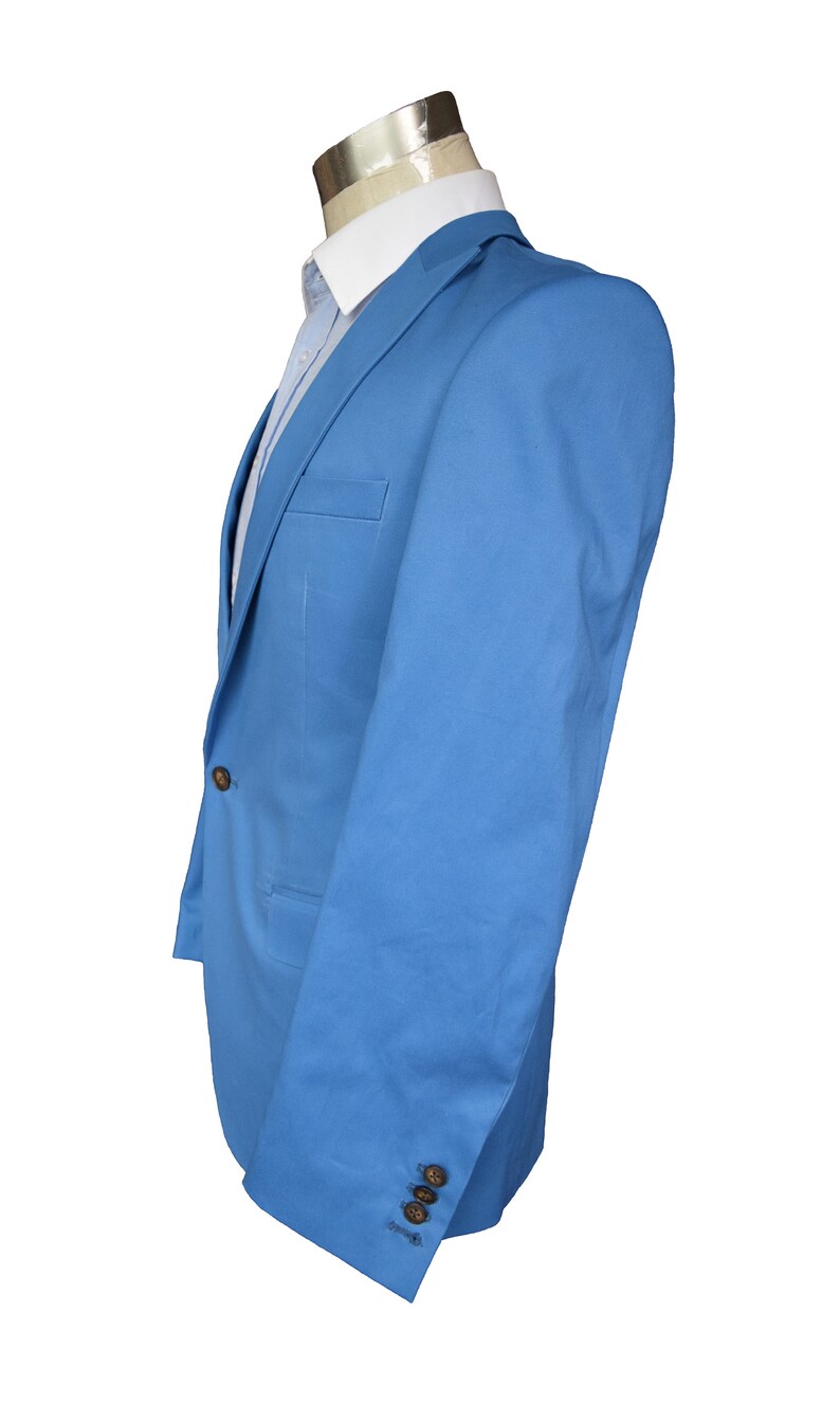 May include: A light blue blazer with a single button closure and two pockets. The blazer has a plain design and is made of a smooth fabric.