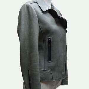 May include: A green leather motorcycle jacket with a zippered pocket on the left side and a zippered closure at the bottom of the sleeves.