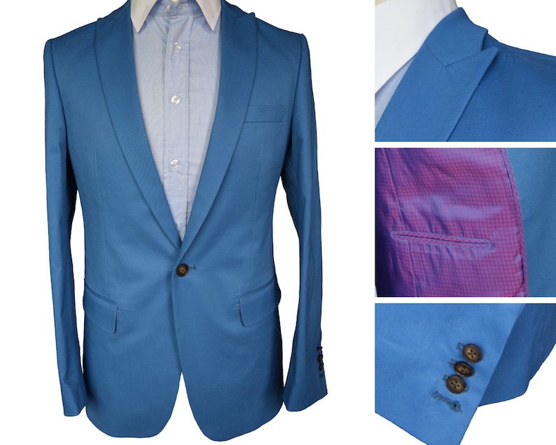 May include: A light blue blazer with a single button closure. The blazer has a notched lapel and a plain front. The lining is a pink and white checkered pattern.