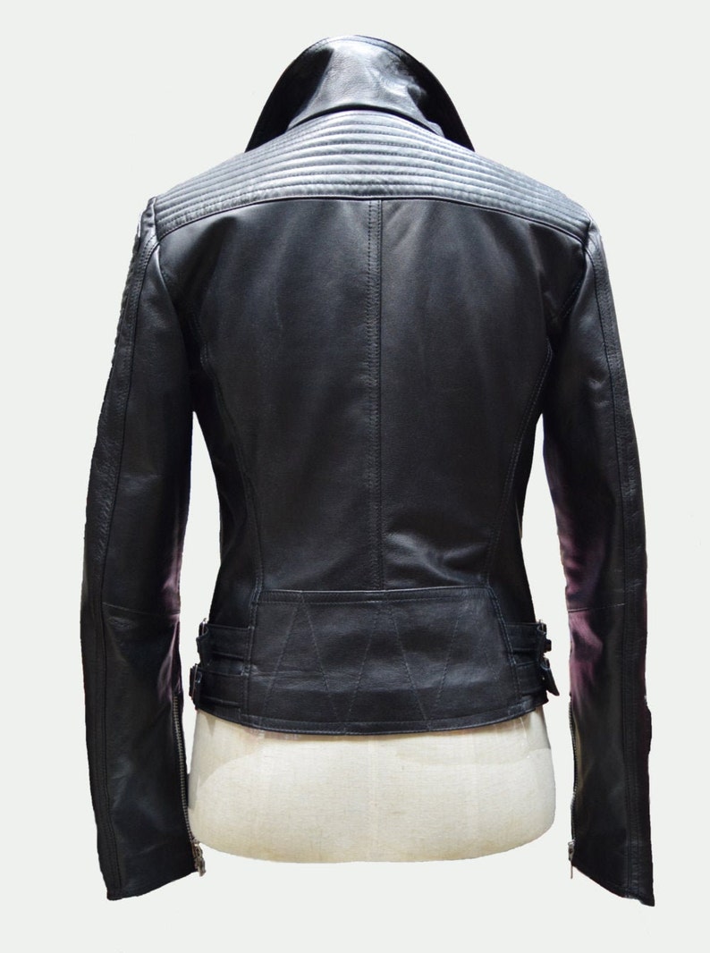 May include: Black leather jacket with a zipper closure and a stand-up collar. The jacket has a quilted design on the back and a belt at the waist.