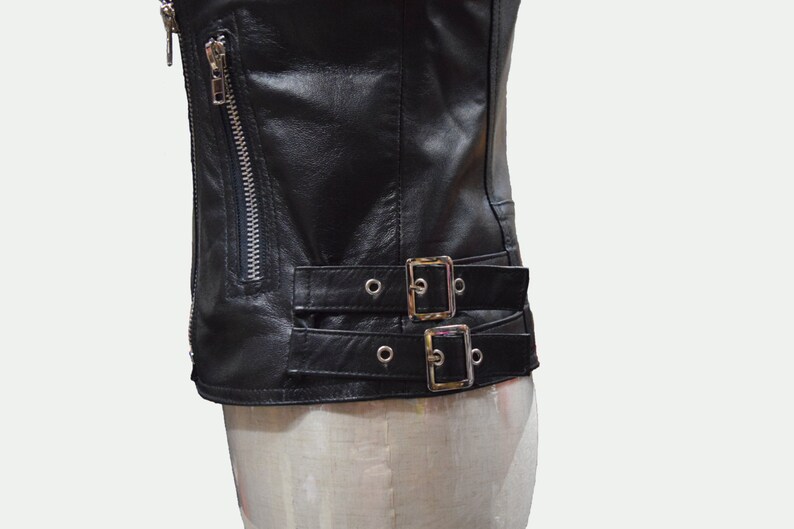 May include: Black leather jacket with a zipper closure and two buckle straps at the waist.