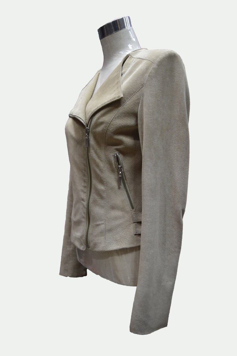 May include: A beige suede jacket with a zipper closure and a collar that can be worn up or down.