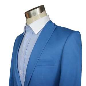 May include: A light blue blazer with a white collared shirt underneath.