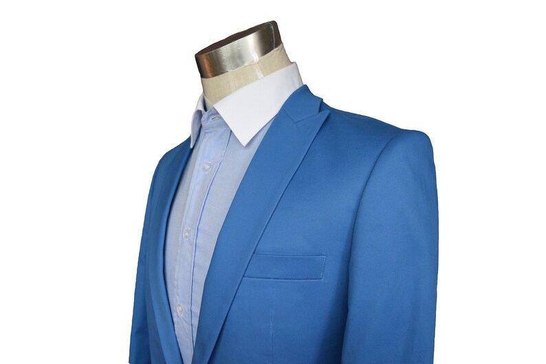 May include: A light blue blazer with a white collared shirt underneath.