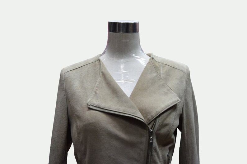 May include: A beige suede jacket with a zipper closure and a v-neck collar.