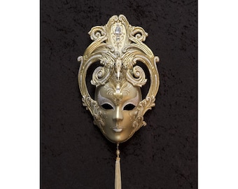 May include: A gold and silver Venetian masquerade mask with intricate details and a white tassel.