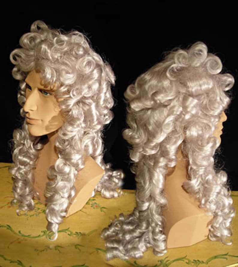 May include: A long, white wig with large, loose curls. The wig is styled in a traditional, historical fashion.