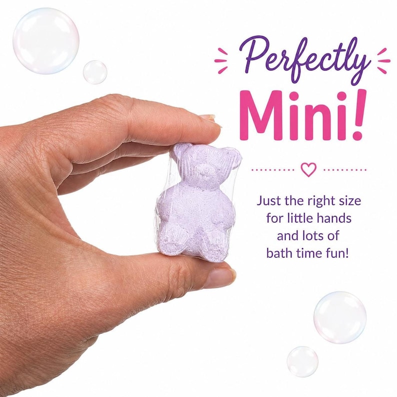 A hand holds a single shrink-wrapped purple bear bath bomb against a white background with floating bubbles.