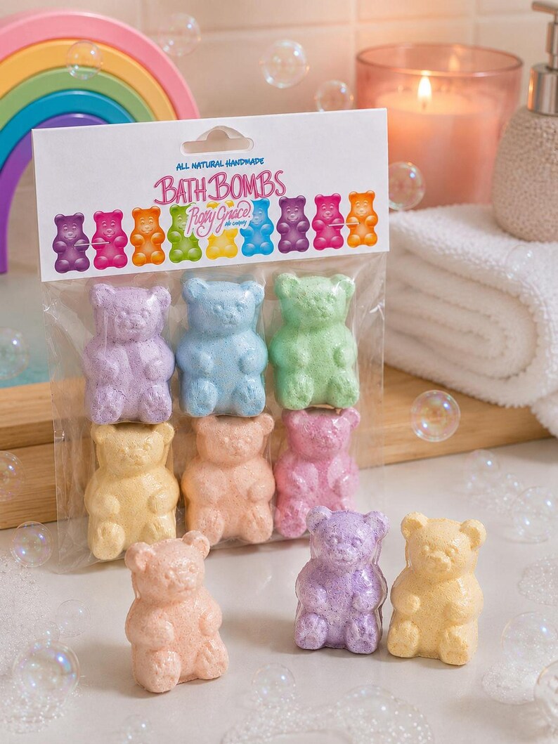 A package of six bear bath bombs stands upright behind four loose bears near a candle and a rainbow prop.