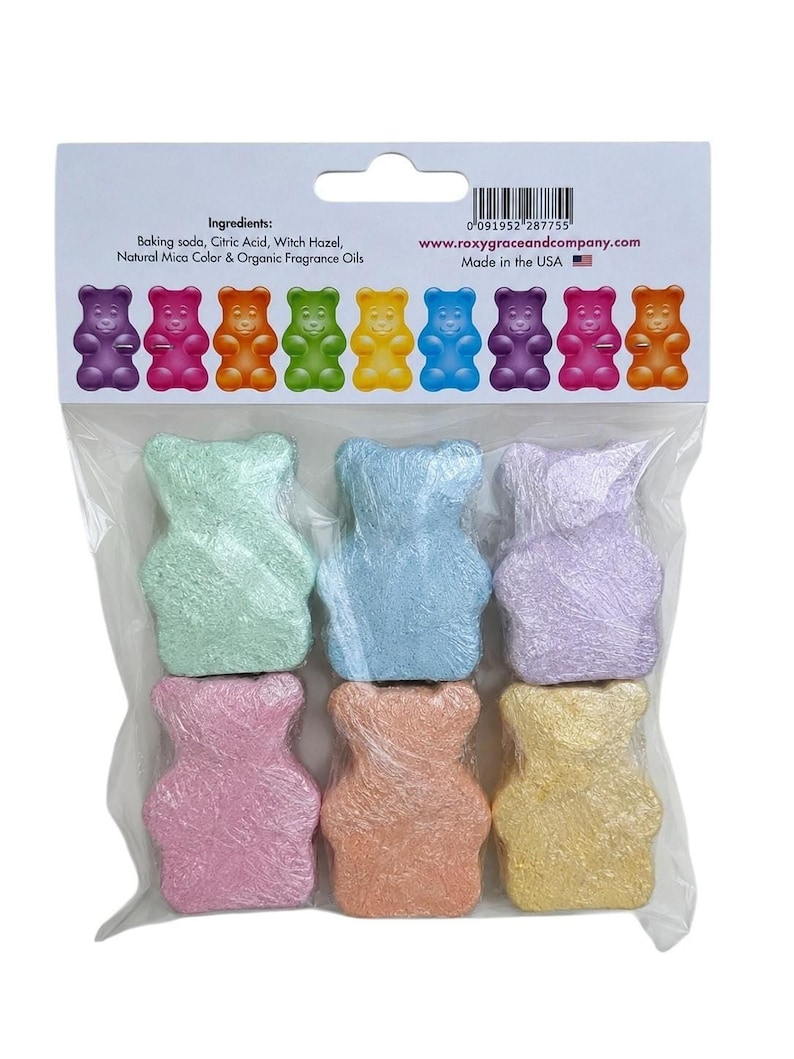A clear plastic bag contains six individually wrapped colorful bear-shaped bath bombs below a cardboard header listing ingredients and website details.