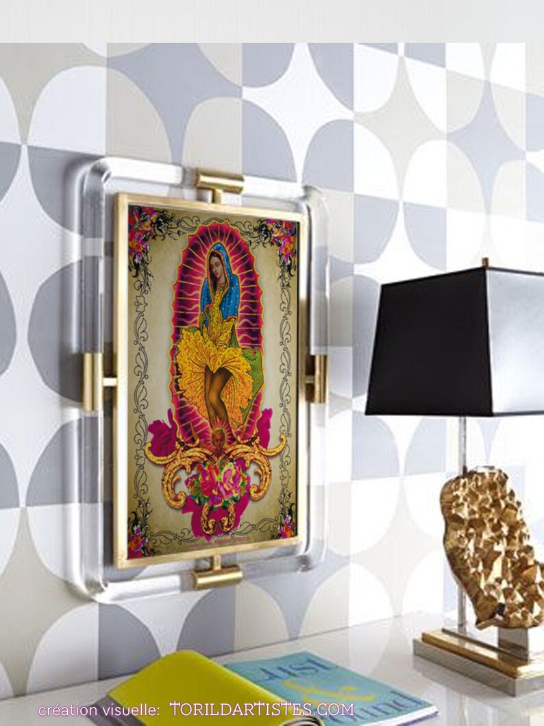 Puede incluir: Una impresi&oacute;n enmarcada de una ilustraci&oacute;n colorida de una mujer con un vestido azul y una falda amarilla. La mujer est&aacute; rodeada de flores y un fondo rosa. El marco es de acr&iacute;lico transparente y tiene un borde dorado. La impresi&oacute;n est&aacute; titulada "creation visuelle: TORILDARTISTES.COM".