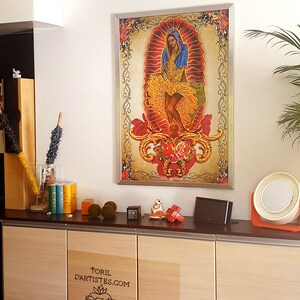 Puede incluir: Una impresi&oacute;n enmarcada de una imagen religiosa colorida que representa a una mujer con un vestido azul y amarillo con una corona de flores. La imagen est&aacute; sobre un fondo dorado con detalles florales ornamentados. El marco es plateado y tiene un dise&ntilde;o simple.