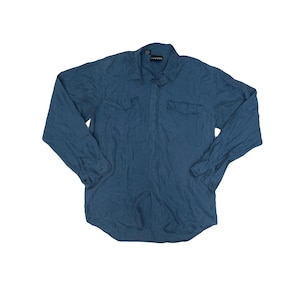 May include: A long-sleeved, teal-colored button-down shirt with two chest pockets. The shirt has a collared neckline and buttoned cuffs. The fabric appears to have a slightly textured, crinkled appearance. The brand name is visible on the collar.