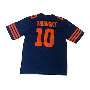 Pode incluir: Uma camisa de futebol azul marinho com listras laranja e brancas nas mangas. A parte de trás da camisa tem o nome "TRUBISKY" e o número "10" em laranja.