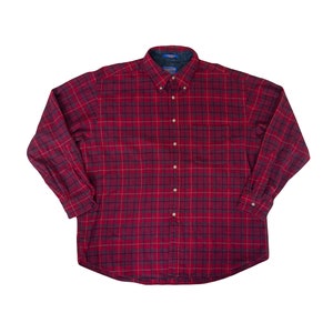 May include: A red and black checked long-sleeved button-down shirt.