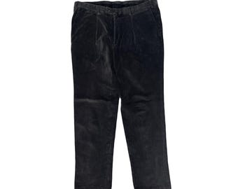 May include: Dark gray corduroy pants with a classic fit. The pants have a button and zipper closure, belt loops, and front pleats. The fabric has a soft, velvety texture.