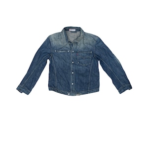 Puede incluir: Chaqueta vaquera azul medio con cierre de botones, dos bolsillos en el pecho y mangas largas. La chaqueta tiene un cuello clásico y un aspecto descolorido. La chaqueta es de corte estándar.