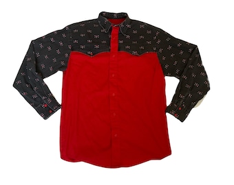 May include: A red and black long-sleeved button-up shirt with a black and white pattern on the sleeves. The shirt has two chest pockets.